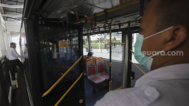 Bus Transjakarta berhenti untuk menaikkan dan menurunkan penumpang di Halte Transjakarta Bundaran HI, Jakarta, Senin (12/10/2020). [Suara.com/Angga Budhiyanto]