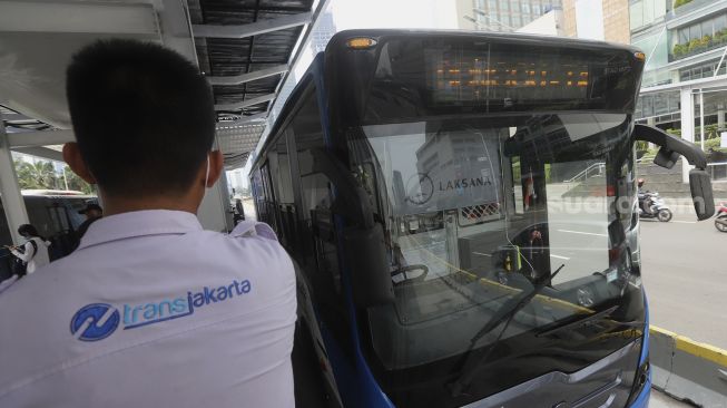 Bus Transjakarta berhenti untuk menaikkan dan menurunkan penumpang di Halte Transjakarta Bundaran HI, Jakarta, Senin (12/10/2020). [Suara.com/Angga Budhiyanto]