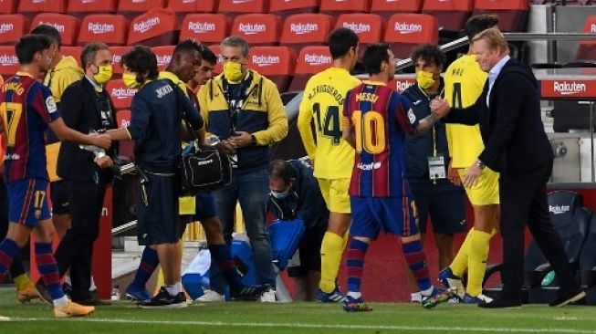 Pelatih Barcelona Ronald Koeman (kanan) menyalami Lionel Messi usai menjamu Villarreal di Camp Nou dalam lanjutan Liga Spanyol. Josep LAGO / AFP