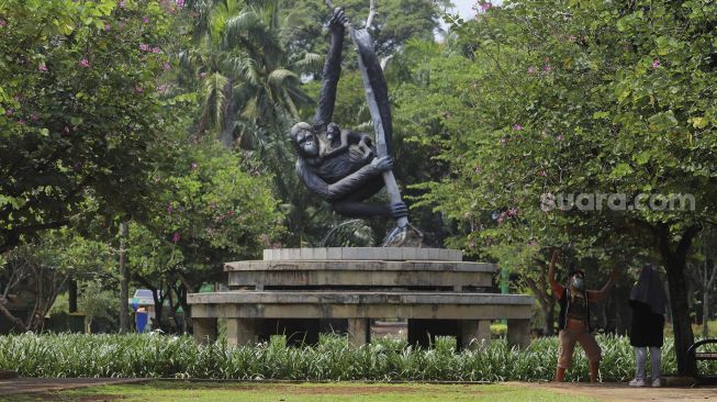 Pengunjung berfoto di Taman Margasatwa Ragunan, Jakarta, Selasa (13/10/2020). [Suara.com/Angga Budhiyanto]