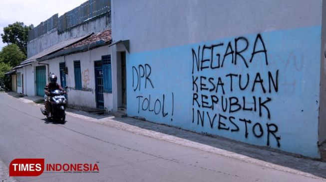 Seorang warga melintas di jalan yang dipenuhi oleh aksi vandalisme di Kota Tua Indramayu. (Foto: Muhamad Jupri/TIMES Indonesia)