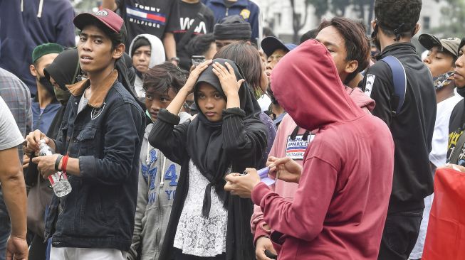 Anak di bawah umur mengikuti aksi tolak UU Cipta Kerja di kawasan Patung Kuda, Jakarta, Selasa (13/10/2020).   [ANTARA FOTO/Muhammad Adimaja]