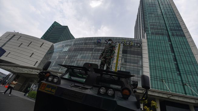 Prajurit Yonif Mekanis 202/Taji Malela berdiri di atas Panser Anoa yang disiagakan di Senayan City, Jakarta Selatan, Selasa (13/10/2020).   [ANTARA FOTO/Sigid Kurniawan]