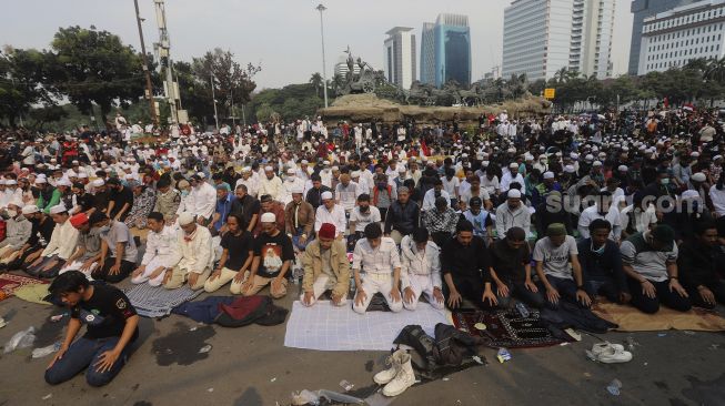 Sejumlah massa dari Persaudaraan Alumni (PA) 212 dan sejumlah ormas Islam melaksanakan Shalat Ashar berjamaah disela-sela menggelar aksi unjuk rasa di kawasan Patung Kuda, Jakarta, Selasa (13/10/2020). [Suara.com/Angga Budhiyanto]