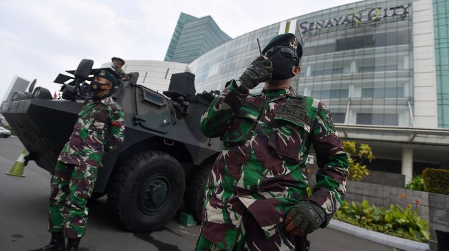 Prajurit Yonif Mekanis 202/Taji Malela berdiri disamping  Panser Anoa yang disiagakan di Senayan City, Jakarta Selatan, Selasa (13/10/2020).   [ANTARA FOTO/Sigid Kurniawan]