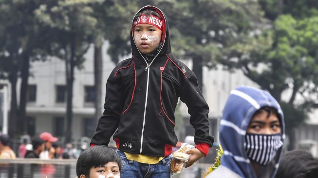 Anak di bawah umur mengikuti aksi tolak UU Cipta Kerja di kawasan Patung Kuda, Jakarta, Selasa (13/10/2020).   [ANTARA FOTO/Muhammad Adimaja]