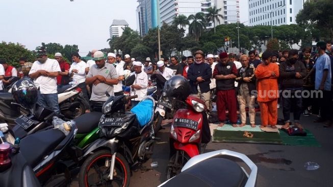 Massa aksi 1310 dari gabungan ormas FPI hingga PA 212 melaksanakan salat berjemaah di tengah jalan. (Suara.com/Wely Hidayat)