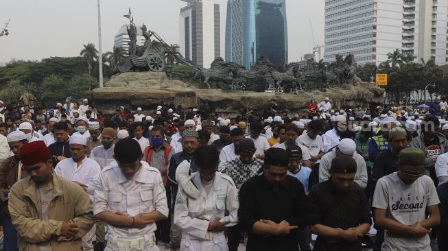 Sejumlah massa dari Persaudaraan Alumni (PA) 212 dan sejumlah ormas Islam melaksanakan Shalat Ashar berjamaah disela-sela menggelar aksi unjuk rasa di kawasan Patung Kuda, Jakarta, Selasa (13/10/2020). [Suara.com/Angga Budhiyanto]