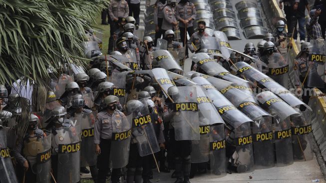 Polisi melakukan pengamanan saat sejumlah massa melakukan aksi tolak UU Cipta Kerja di kawasan Patung Kuda, Jakarta, Selasa (13/10/2020). [Suara.com/Angga Budhiyanto]