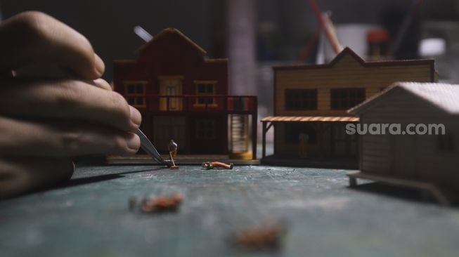 Tristan Saputra (36) menyelesaikan pembuatan miniatur tiga dimensi atau diorama di Khals Miniatur, Otista 3 Raya, Jakarta, Rabu (14/10/2020). [Suara.com/Angga Budhiyanto]