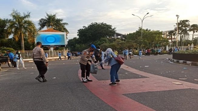 Usai melaksanakan demonstransi penolakan UU Cipta Kerja di depan kantor Gubernur Riau, Selasa 13 Oktober 2020, para demonstran membersihkan sisa sampah yang berserakan di jalan Sudirman. (Foto: Riauonline.co.id)