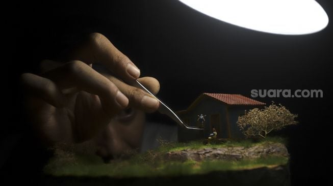 Tristan Saputra (36) menyelesaikan miniatur tiga dimensi atau diorama di Khals Miniatur, Otista 3 Raya, Jakarta, Rabu (14/10/2020). [Suara.com/Angga Budhiyanto]