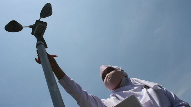 Seorang petugas Badan Meteorologi Klimatologi dan Geofisika (BMKG) mencatat kecepatan angin pada anemometer di stasiun Klimatologi BMKG Karangploso, Malang, Jawa Timur, Kamis ( 15/10/2020).  [ANTARA FOTO/Ari Bowo Sucipto]