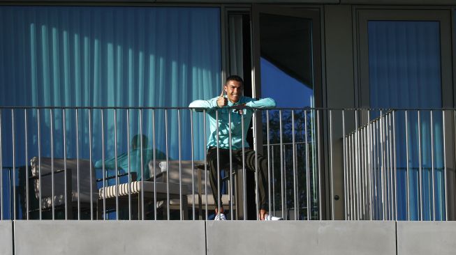 Cristiano Ronaldo saat menonton timnas Portugal latihan di balkon Hotel kamp pelatihan timnas Portugal, Lisabon, Portugal, 13 Oktober 2020.  [Diogo PINTO / Federasi Sepak Bola Portugis (FPF) / AFP]