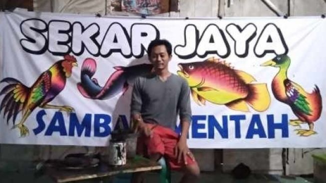 Kenalkan, Ini Salah Satu Pelukis Spesialis Spanduk Pecel Lele Khas Lamongan