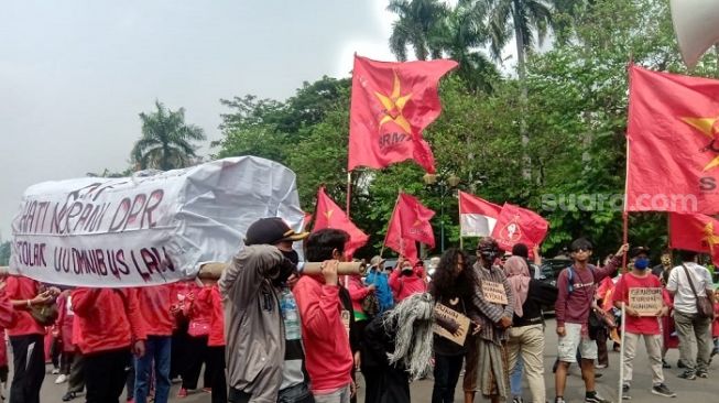 Buruh dari SRMI membawa keranda mayat saat menggelar aksi tolak UU Cipta Kerja di depan Istana. (Suara.com/Arga)