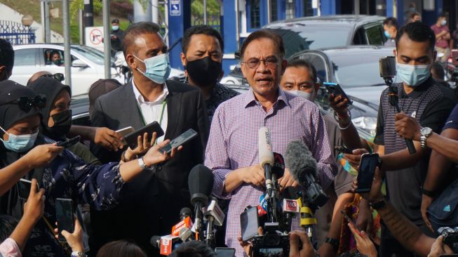 Pemimpin oposisi Malaysia yang juga Presiden Partai Keadilan Rakyat (PKR) Dato' Sri Anwar Ibrahim (tengah) didampingi pengacaranya Ramkapal Singh (kiri) melakukan jumpa pers di depan kantor Polisi Diraja Malaysia (PDRM) Bukit Aman, Kuala Lumpur, Malaysia, Jumat (16/10/2020).  [ANTARA FOTO/Agus Setiawan]