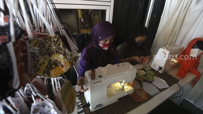 Pekerja menyelesaikan pembuatan masker berbahan kain batik di Butik Elemwe, Rawamangun, Jakarta, Jumat (16/10/2020). [Suara.com/Angga Budhiyanto]