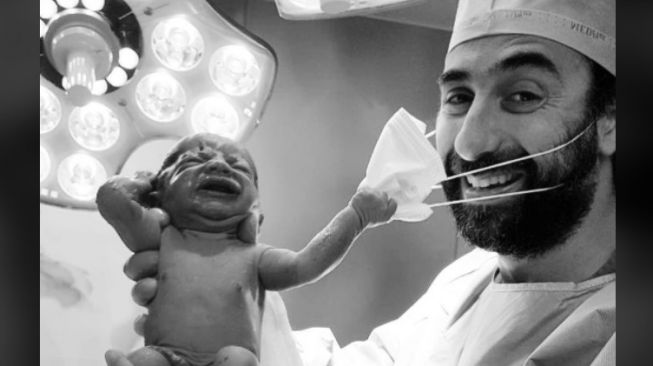 Viral Foto Bayi Baru Lahir Tarik Masker Dokter Warga Pertanda Baik