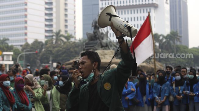 Seorang mahasiswa yang tergabung dalam Badan Eksekutif Mahasiswa Seluruh Indonesia (BEM SI) berorasi saat menggelar aksi unjuk rasa di kawasan Patung Kuda, Jakarta, Jumat (16/10/2020). [Suara.com/Angga Budhiyanto]