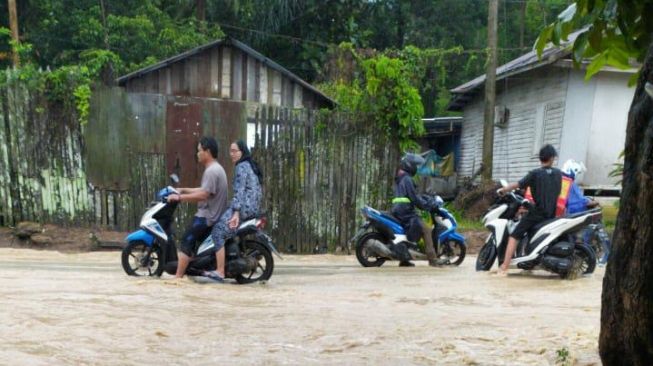 Pengendara roda dua memutuskan balik arah melihat kondisi banjir di kawasan Kebon agung, Samarinda (Foto: Yovanda)