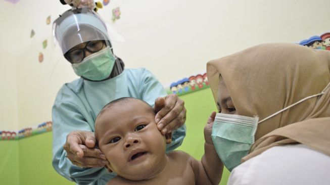 Seorang pemijat memijat bayi saat perawatan di Baby Spa Umay and Mom, Kota Garut, Kabupaten Garut, Jawa Barat, Sabtu (17/10/2020). [ANTARA FOTO/Candra Yanuarsyah]