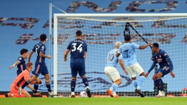 Pemain Manchester City Raheem Sterling menjebol gawang Arsenal dalam pertandingan Liga Premier Inggris yang berlangsung di Etihad Stadium, Sabtu (18/10/2020). [AFP]