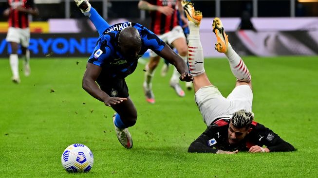 Pemain depan Inter Milan Romelu Lukaku (Kiri) bertarung memperebutkan bola dengan bek AC Milan Theo Hernandez saat pertandingan sepak bola Serie A Italia antara Inter Milan melawan AC Milan di Stadion Giuseppe Meazza, Milan, Italia, Minggu (18/10) dini hari WIB. [Miguel MEDINA / AFP]