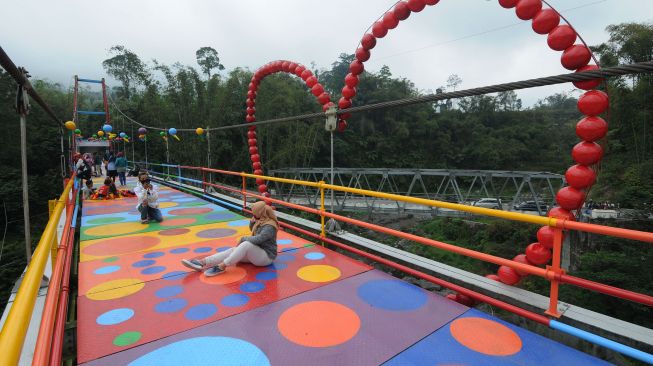 Sejumlah pengunjung berfoto saat mengunjungi Jembatan Polkadot Merapi di Klakah, Selo, Boyolali, Jawa Tengah, Sabtu (17/10/2020).  [ANTARA FOTO/Aloysius Jarot Nugroho]
