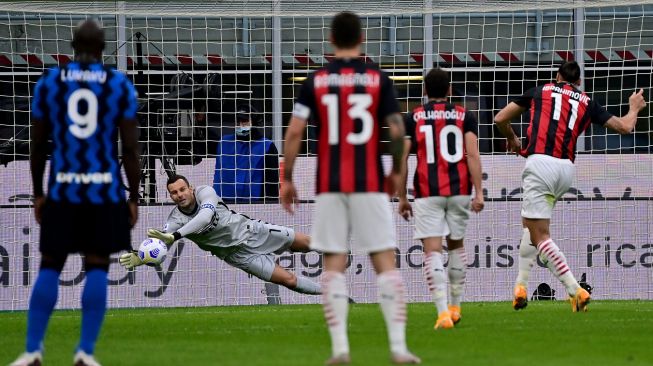 Penyerang AC Milan Zlatan Ibrahimovic (kanan) menembak dan mencetak gol melewati kiper Inter Milan Samir Handanovic selama pertandingan sepak bola Serie A Italia antara Inter Milan melawan AC Milan di Stadion Giuseppe Meazza, Milan, Italia, Minggu (18/10) dini hari WIB.  [Miguel MEDINA / AFP]