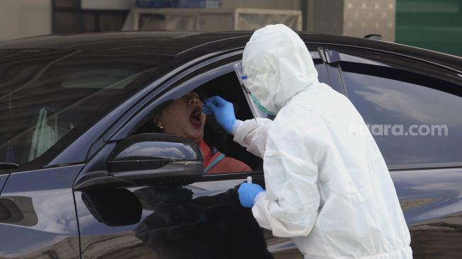 Warga menjalani tes usap PCR (Swab Test) tanpa turun dari kendaraan (drive-thru) di GSI Lab (Genomik Solidaritas Indonesia Laboratorium), Cilandak, Jakarta Selatan, Senin  (19/10/2020). [Suara.com/Angga Budhiyanto]