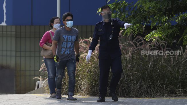 Petugas keamanan melayani warga yang akan menjalani tes usap PCR (Swab Test) di GSI Lab (Genomik Solidaritas Indonesia Laboratorium), Cilandak, Jakarta Selatan, Senin  (19/10/2020). [Suara.com/Angga Budhiyanto]