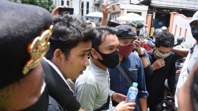 Polisi menangkap 2 remaja berpakaian serba hitam saat demo mahasiswa memperingati satu tahun Jokowi berkuasa di periode 2. (KanalKalimantan)