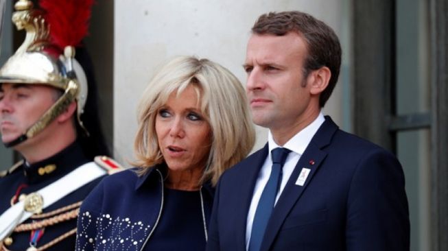 Presiden Prancis Emmanuel Macron dan istrinya Brigitte Macron (tengah) menunggu para tamu sebelum upacara di Elysee Palace untuk merayakan penetapan Kota Paris sebagai penyelenggara Olimpiade Musim Panas 2024, di Prancis, Jumat (15/9/2017). (ANTARA/REUTERS/Charles Platiau/cfo/17) 