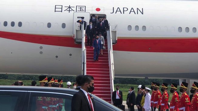 Perdana Menteri Jepang Yoshihide Suga bersama Madam Suga Mariko menuruni tangga pesawat setibanya dari Vietnam di Bandara Soekarno Hatta, Tangerang, Banten, Selasa (20/10/2020). [ANTARA FOTO]