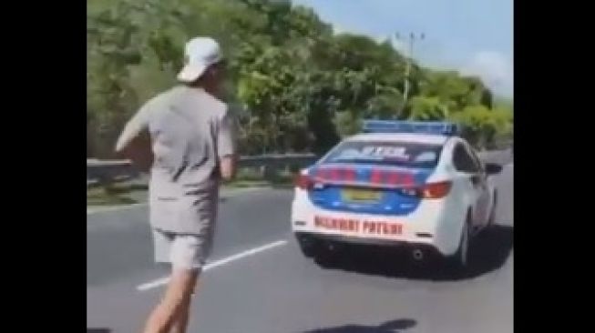 Mobil PJR kawal pria mirip Richard Muljadi joging di Bali. (Twitter)