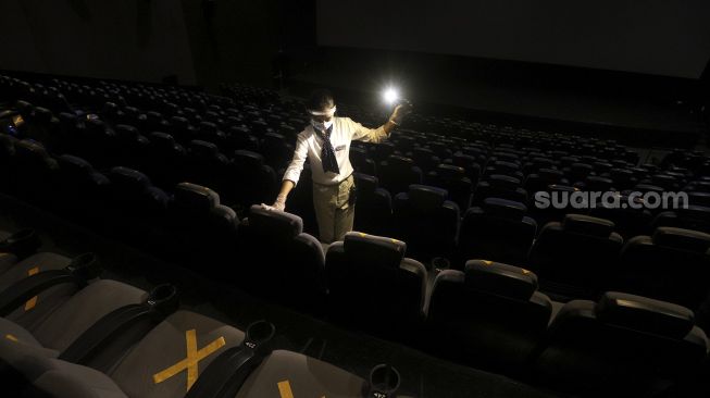 Petugas memeriksa tempat duduk penonton di bioskop CGV Cinemas Grand Indonesia, Jakarta, Rabu (21/10/2020). [Suara.com/Angga Budhiyanto]