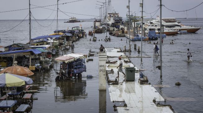 Warga beraktivitas saat banjir rob di Pelabuhan Kali Adem, Muara Angke, Jakarta, Rabu (21/10/2020).  [ANTARA FOTO/Aprillio Akbar]