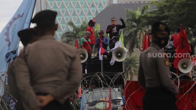 Massa aksi yang tergabung dalam elemen buruh berorasi di atas mobil komando saat berunjuk rasa di kawasan Patung Kuda Arjuna Wiwaha, Jakarta, Kamis (22/10/2020). [Suara.com/Angga Budhiyanto]