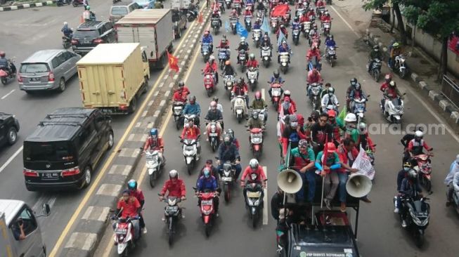 Ribuan Demonstran yang tergabung dalam Aliansi Buruh Banten Bersatu (AB3) kembali melancarkan aksi unjuk rasa tolak Undang-Undang Omnibus Law Cipta Kerja. Mereka melangggang bebas melintasi Jalan Daan Mogot, Kota Tangerang tanpa hambatan menuju Istana Presiden, Jakarta Pusat, Kamis, (22/10/2020). [Suara.com/Irfan Maulana]