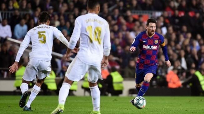 Pemain Barcelona Lionel Messi mencoba menerobos pertahanan Real Madrid dalam pertandingan El Clasico di Camp Nou pada 18 Desember 2019. [AFP]