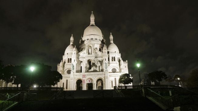 Basilica of the Sacred Heart di Montmartre di distrik 18 Paris, selama jam malam, pada (23/10/2020).  [Valery HACHE / AFP]