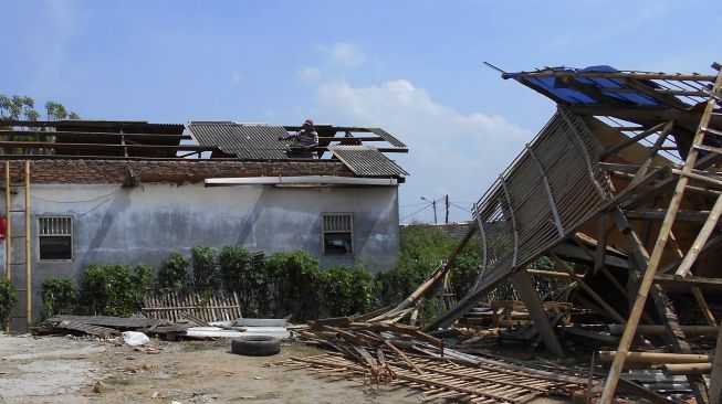 Warga memperbaiki atap rumah yang rusak pascaditerpa angin puting beliung di Bekasi, Jawa Barat, Sabtu (24/10/2020). [ANTARA FOTO/Fakhri Hermansyah]