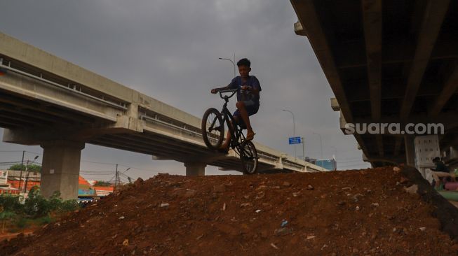 Seorang anak mencoba area lintasan Pump Track di Bike Park Pilar Jati, Kolong Tol Becakayu, Jakarta Timur, Minggu (25/10). [Suara.com/Alfian Winanto]