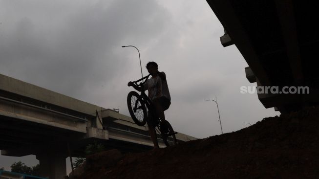 Seorang anak mencoba area lintasan Pump Track di Bike Park Pilar Jati, Kolong Tol Becakayu, Jakarta Timur, Minggu (25/10). [Suara.com/Alfian Winanto]