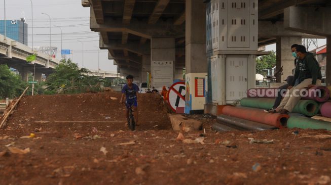 Seorang anak mencoba area lintasan Pump Track di Bike Park Pilar Jati, Kolong Tol Becakayu, Jakarta Timur, Minggu (25/10). [Suara.com/Alfian Winanto]