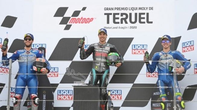Rider Petronas Yamaha SRT Franco Morbidelli (tengah) merayakan kemenangan di podium sebagai juara MotoGP Teruel 2020, sementara dua pembalap Suzuki Alex Rins (kiri) dan Joan Mir di podium kedua dan ketiga. PIERRE-PHILIPPE MARCOU / AFP