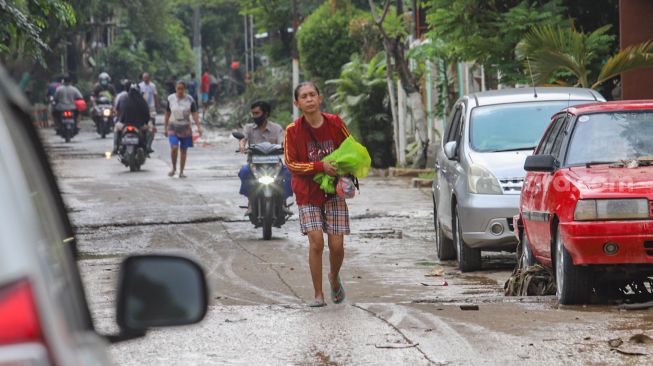 Warga mengungsikan barangnya ke area yang tidak terdampak banjir di Perumahan Villa Jatirasa, Kota Bekasi, Jawa Barat, Minggu (25/10). [Suara.com/Alfian Winanto]