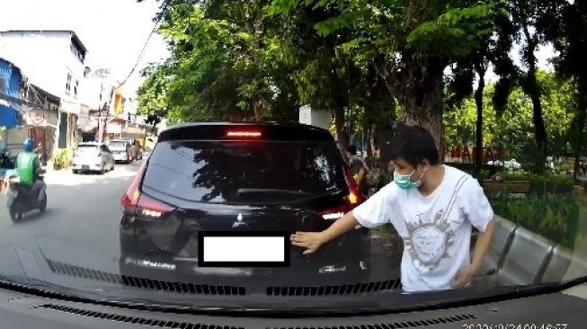 Pemobil memberi tanda dengan mengetok bagian belakang Mitsubishi Xpander (Facebook)