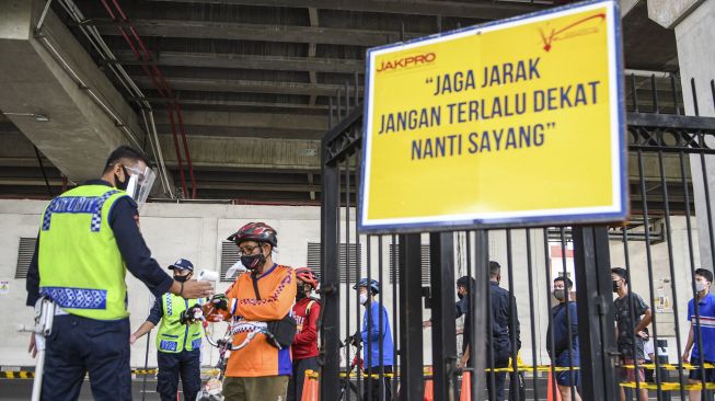 Petugas mengukur suhu tubuh dari warga yang akan berolahraga di Jakarta International Velodrome, Rawamangun, Jakarta, Minggu (25/10/2020).